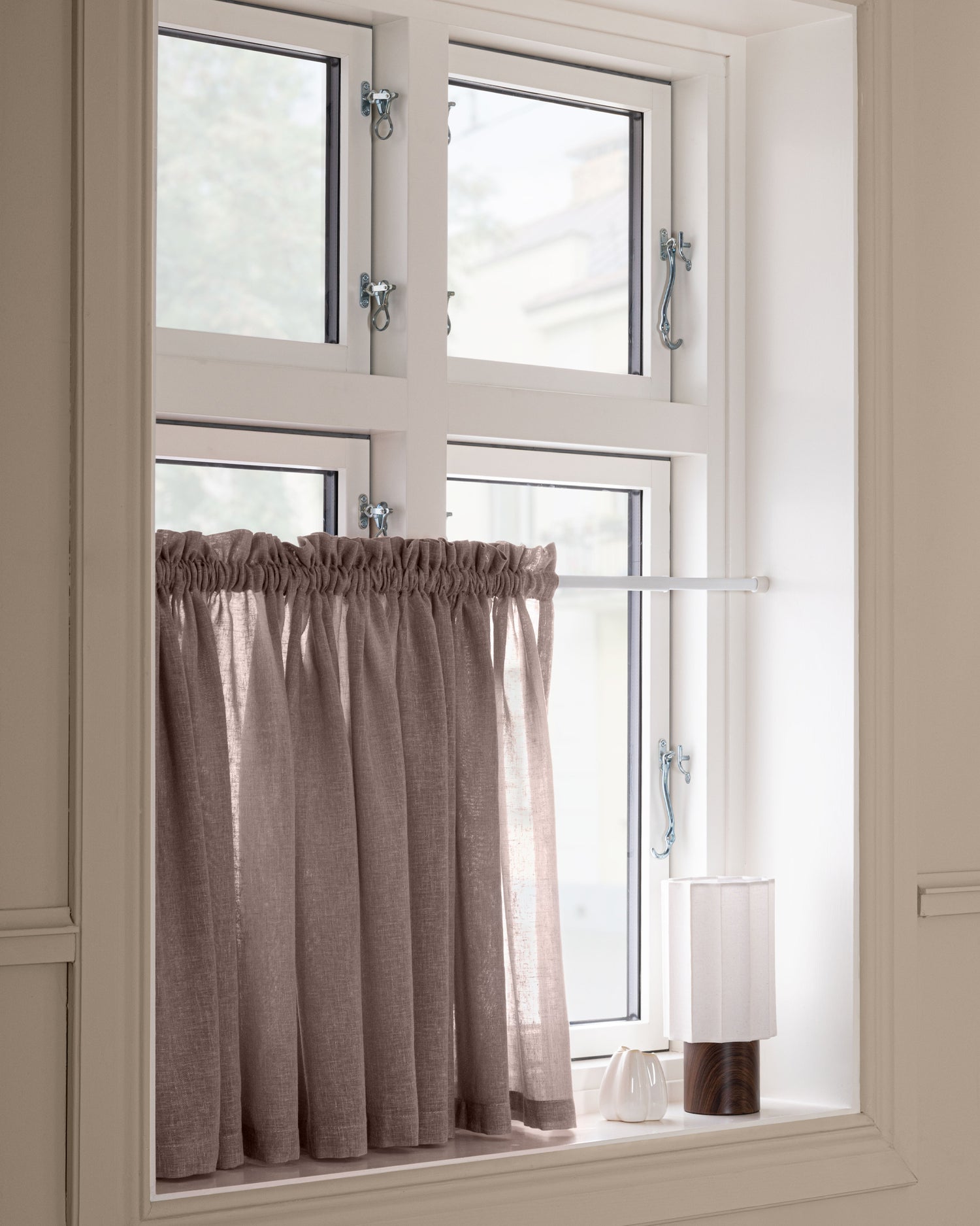 Mörkt beige cafégardin på spännstång i nisch
